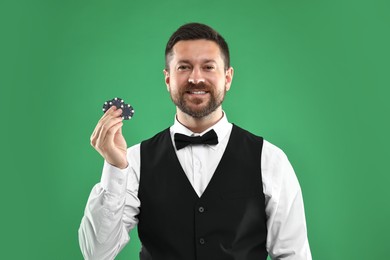 Croupier with casino chips on green background