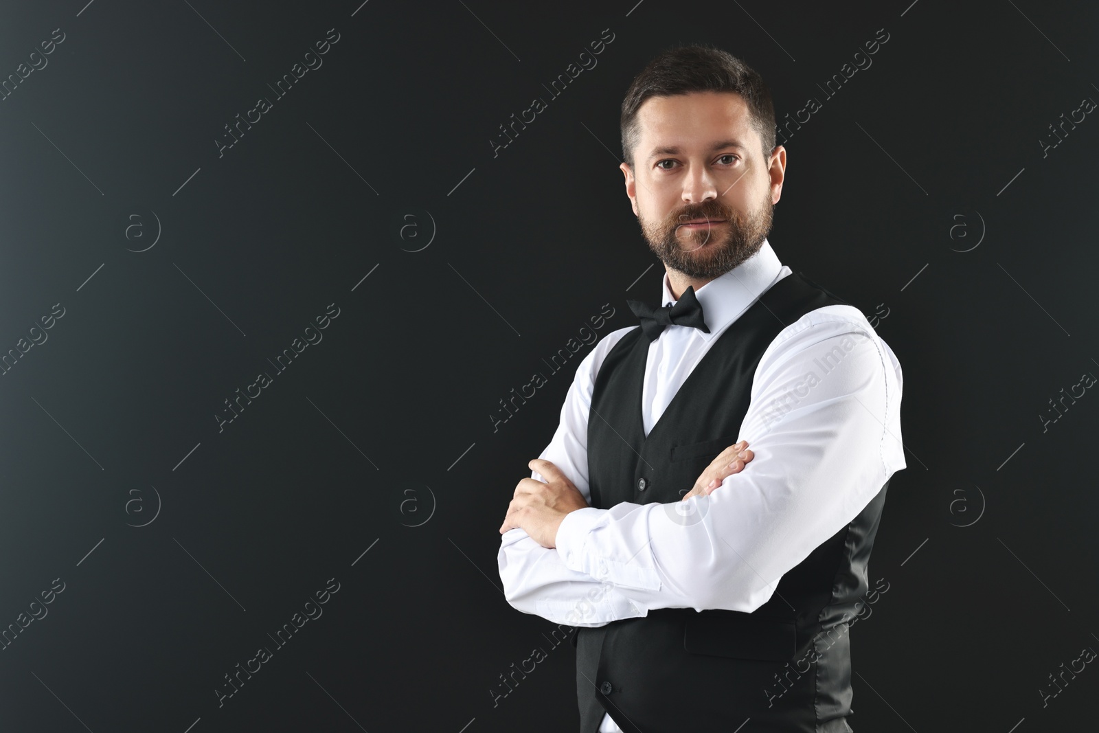 Photo of Portrait of professional croupier on black background, space for text