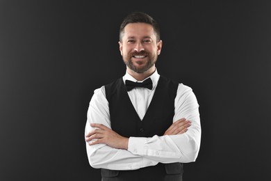 Portrait of professional croupier on black background