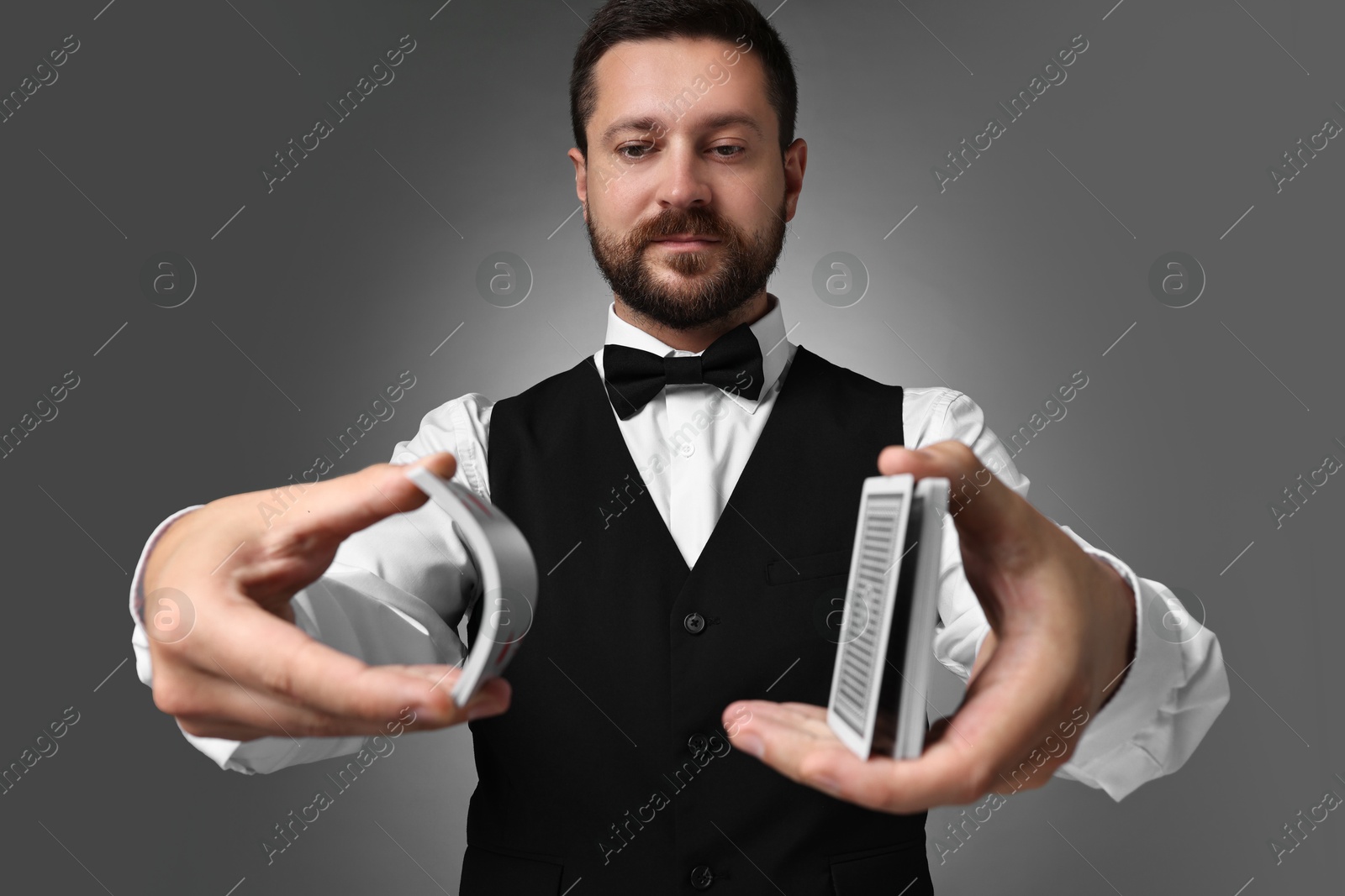 Photo of Professional croupier shuffling cards on grey background