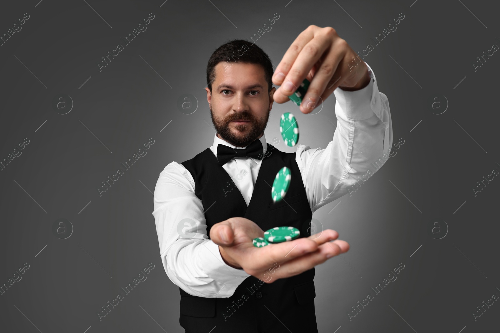 Photo of Croupier with casino chips on grey background