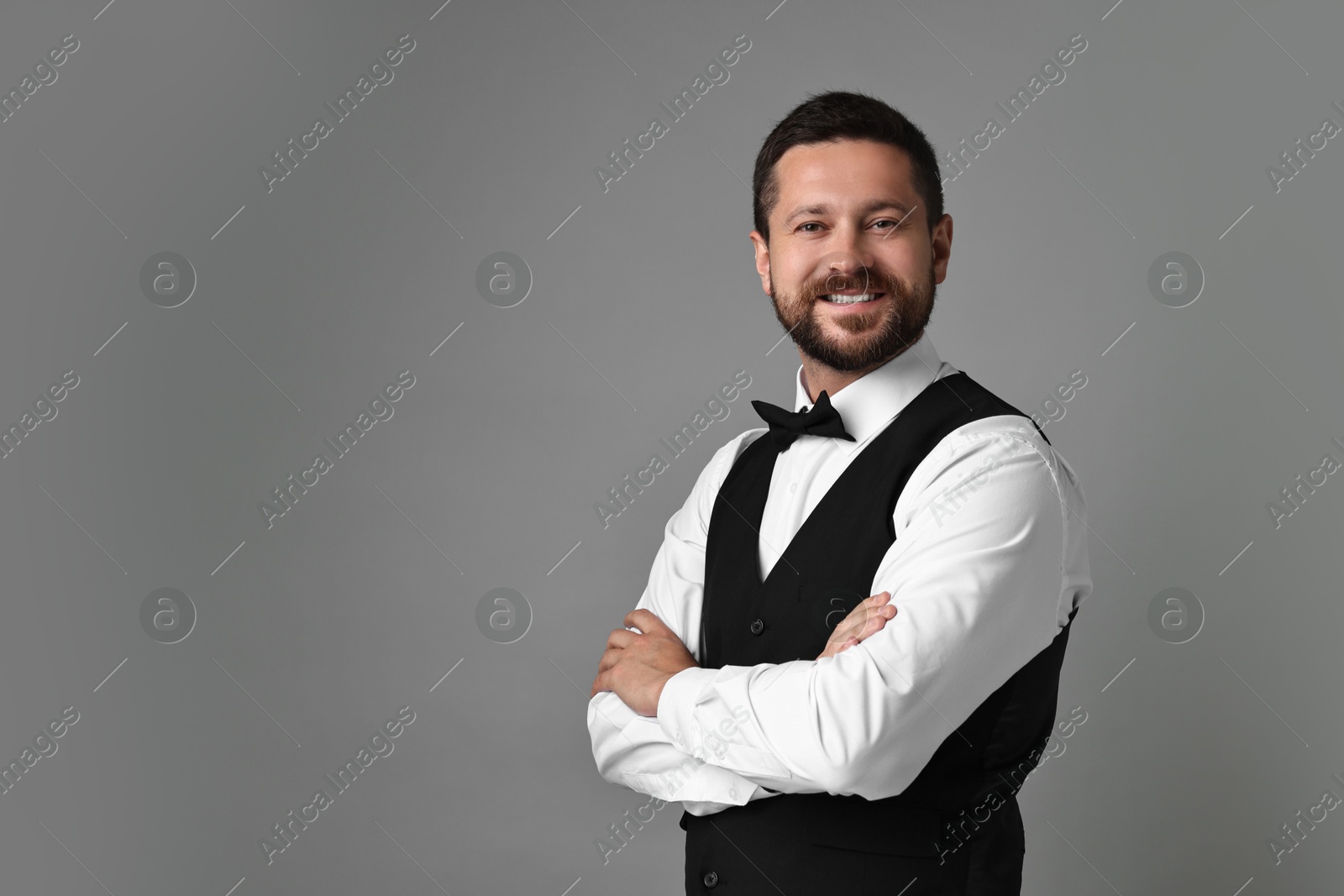 Photo of Portrait of professional croupier on grey background, space for text