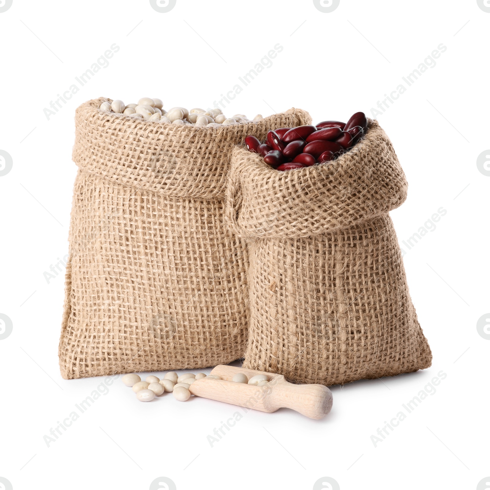 Photo of Burlap sacks with different dried beans and scoop isolated on white