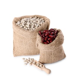 Photo of Burlap sacks with different dried beans and scoop isolated on white