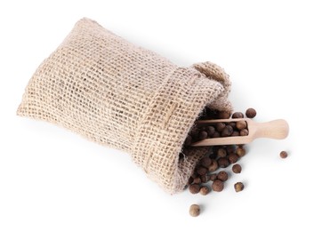 Photo of Burlap sack with allspice and scoop isolated on white, top view