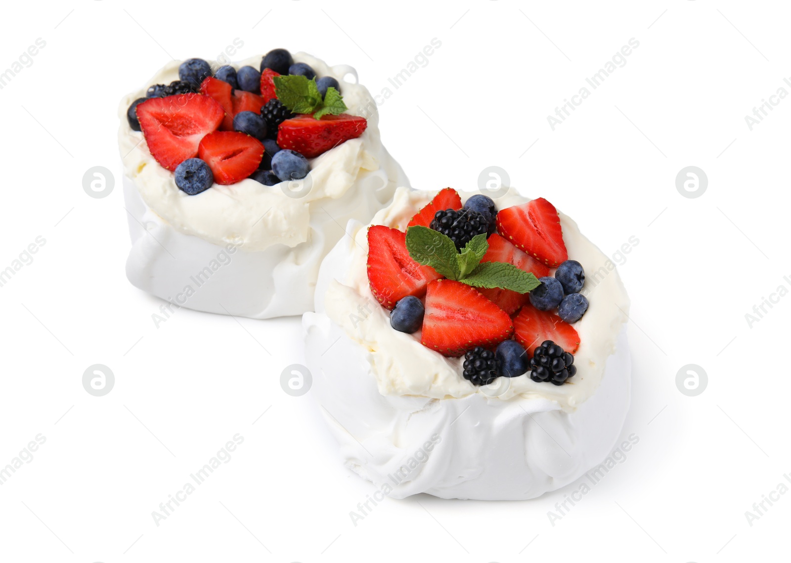 Photo of Pavlova cake (meringue dessert) with whipped cream, fresh berries and mint isolated on white