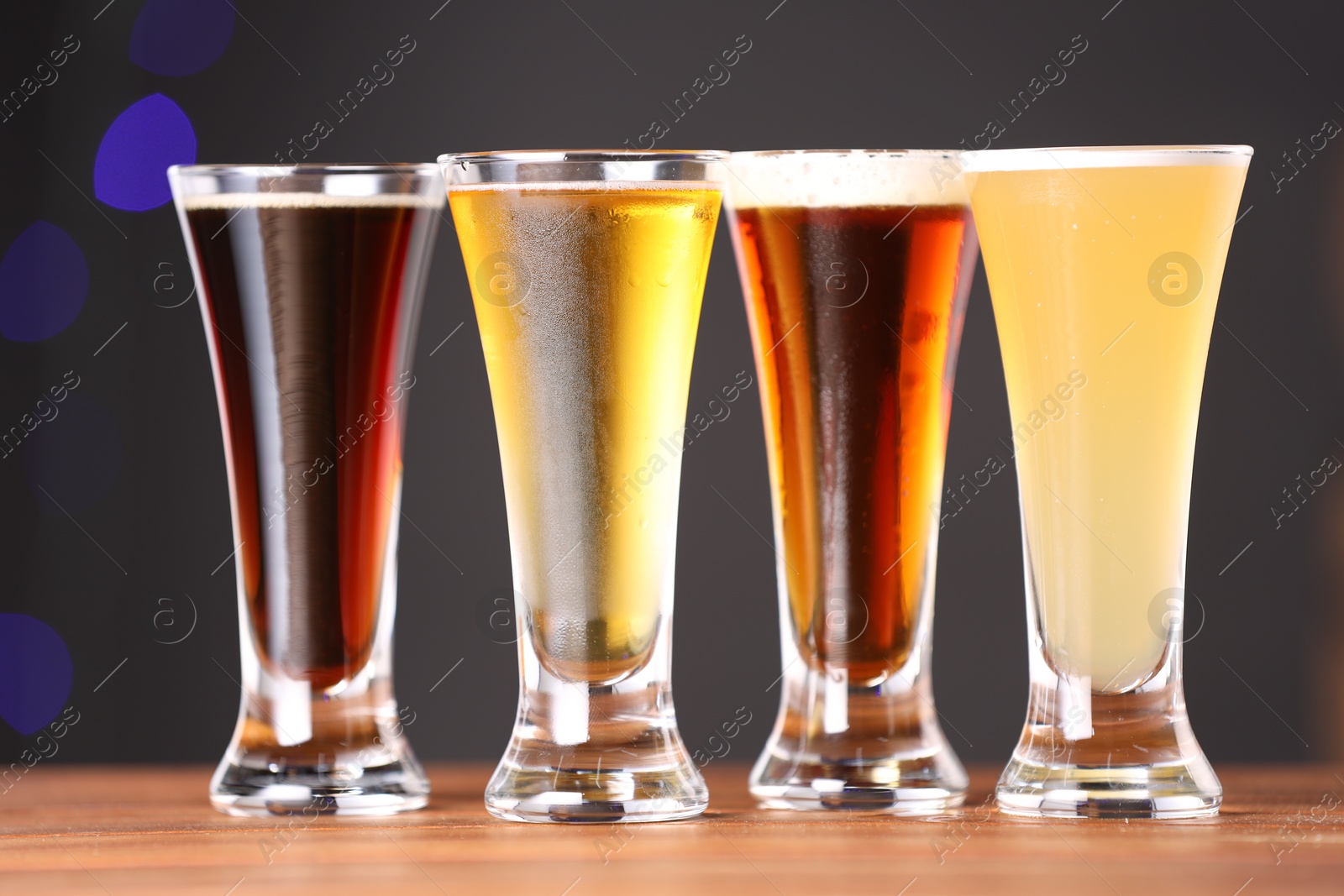 Photo of Glasses with different types of beer on wooden table, closeup