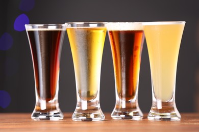 Photo of Glasses with different types of beer on wooden table, closeup