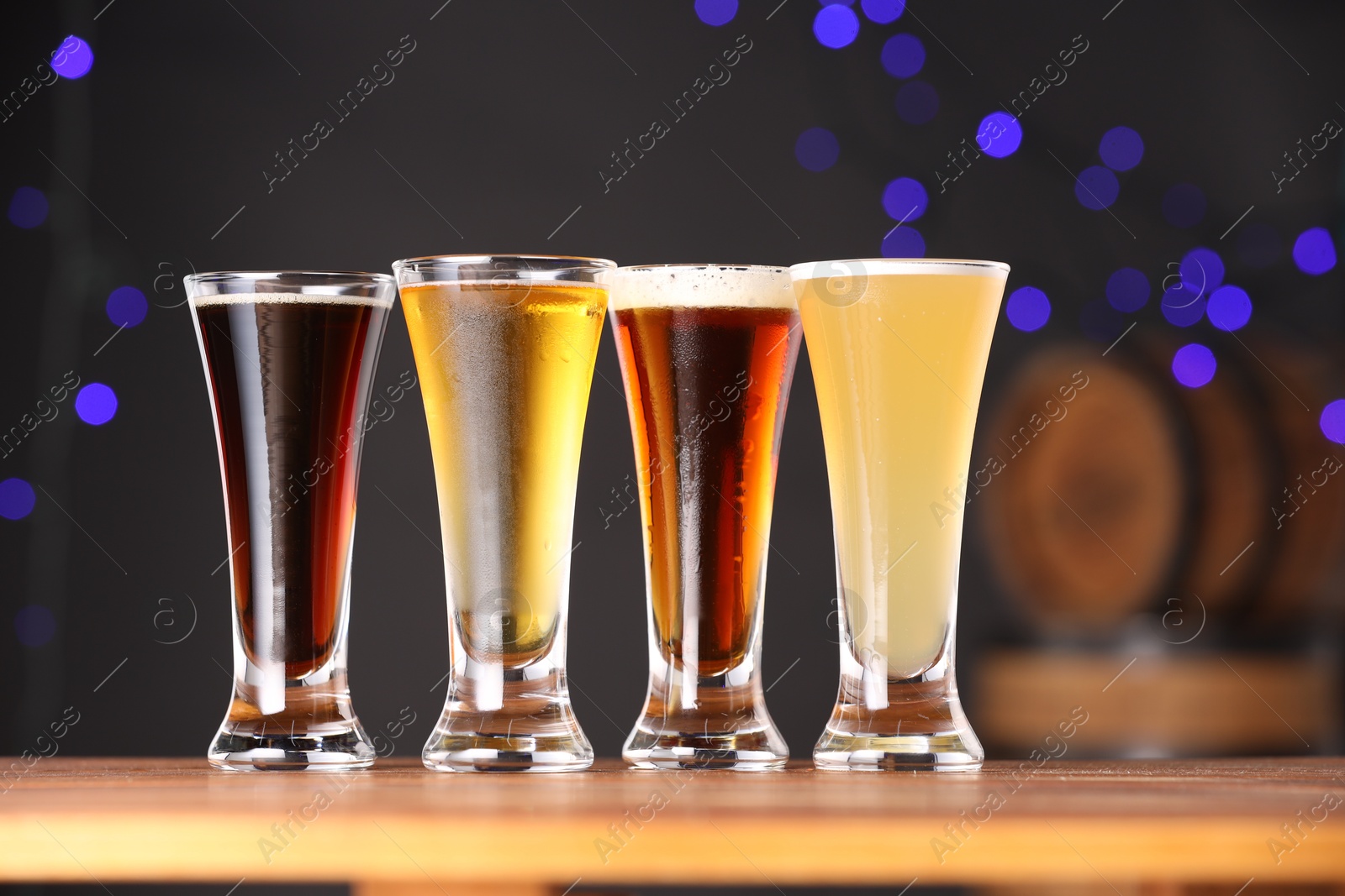 Photo of Glasses with different types of beer on wooden table, closeup