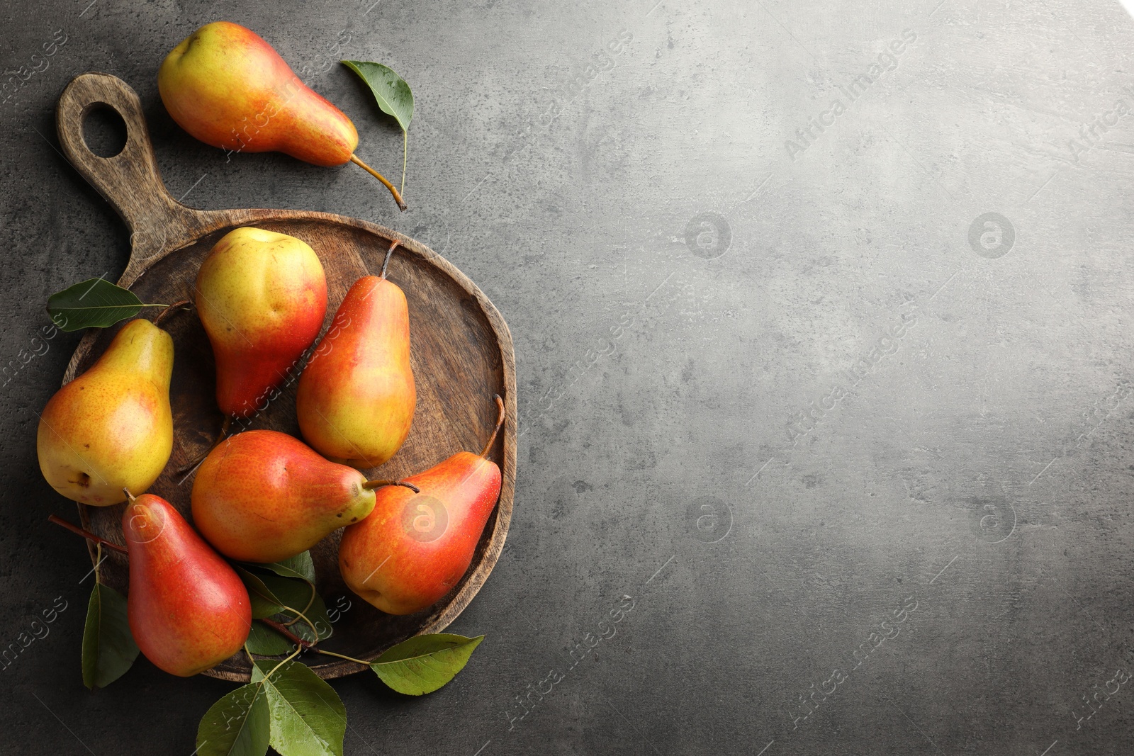 Photo of Ripe juicy pears on grey table, flat lay. Space for text