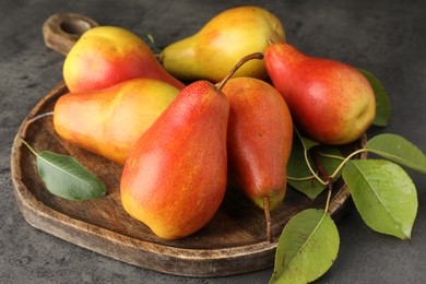 Photo of Ripe juicy pears on grey table, closeup