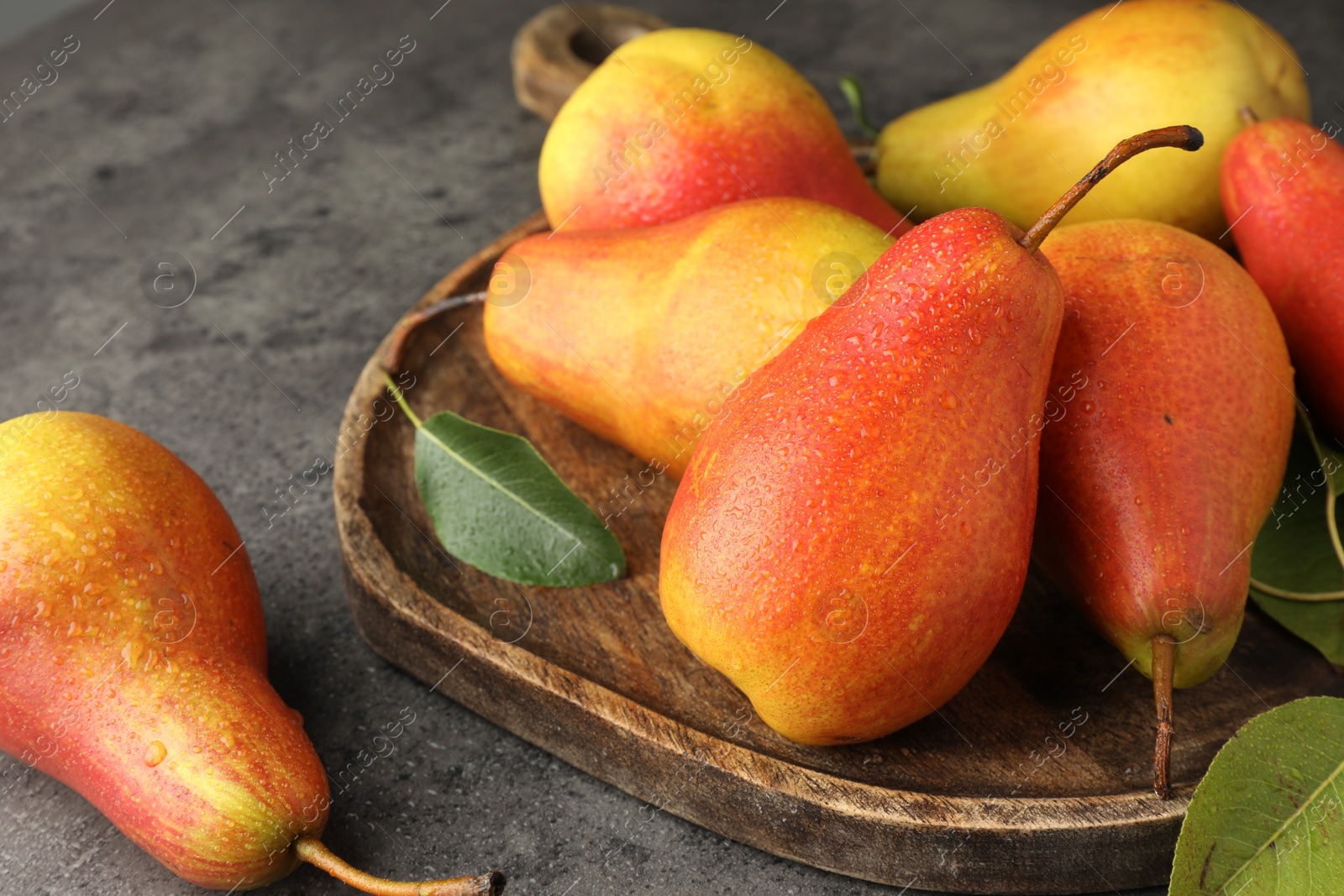 Photo of Ripe juicy pears on grey table, closeup