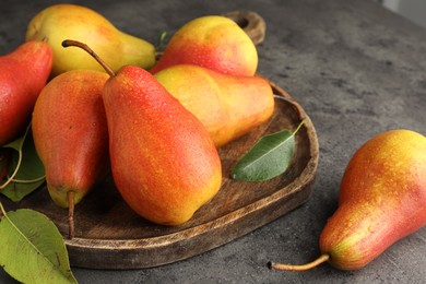 Photo of Ripe juicy pears on grey table, closeup