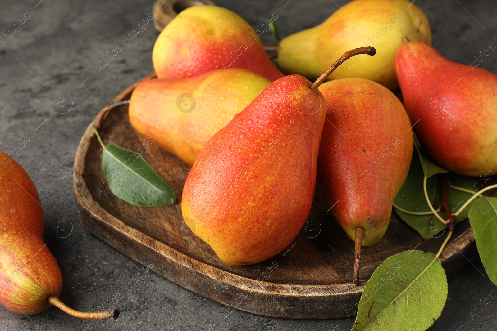 Photo of Ripe juicy pears on grey table, closeup