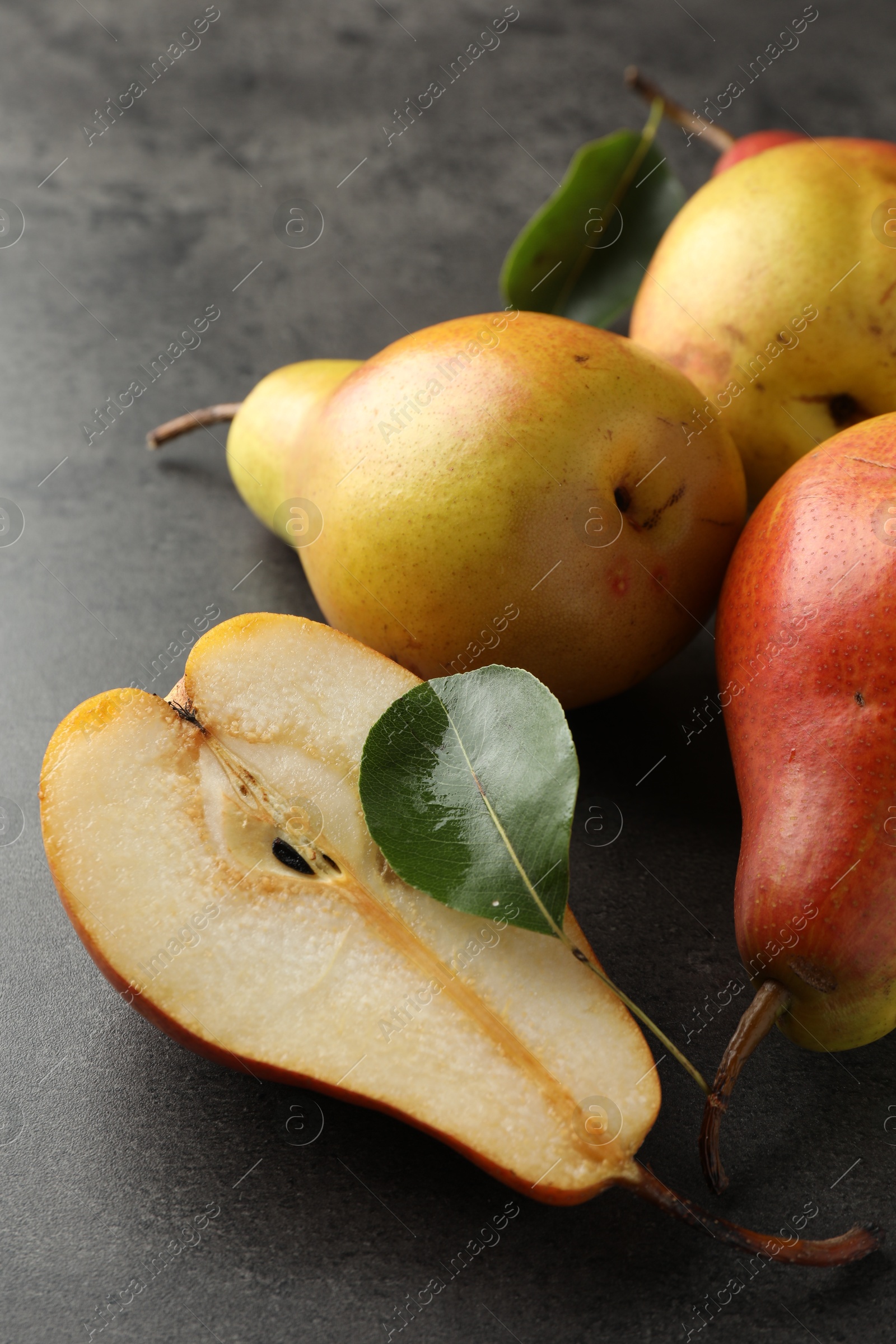 Photo of Ripe juicy pears on grey table, closeup