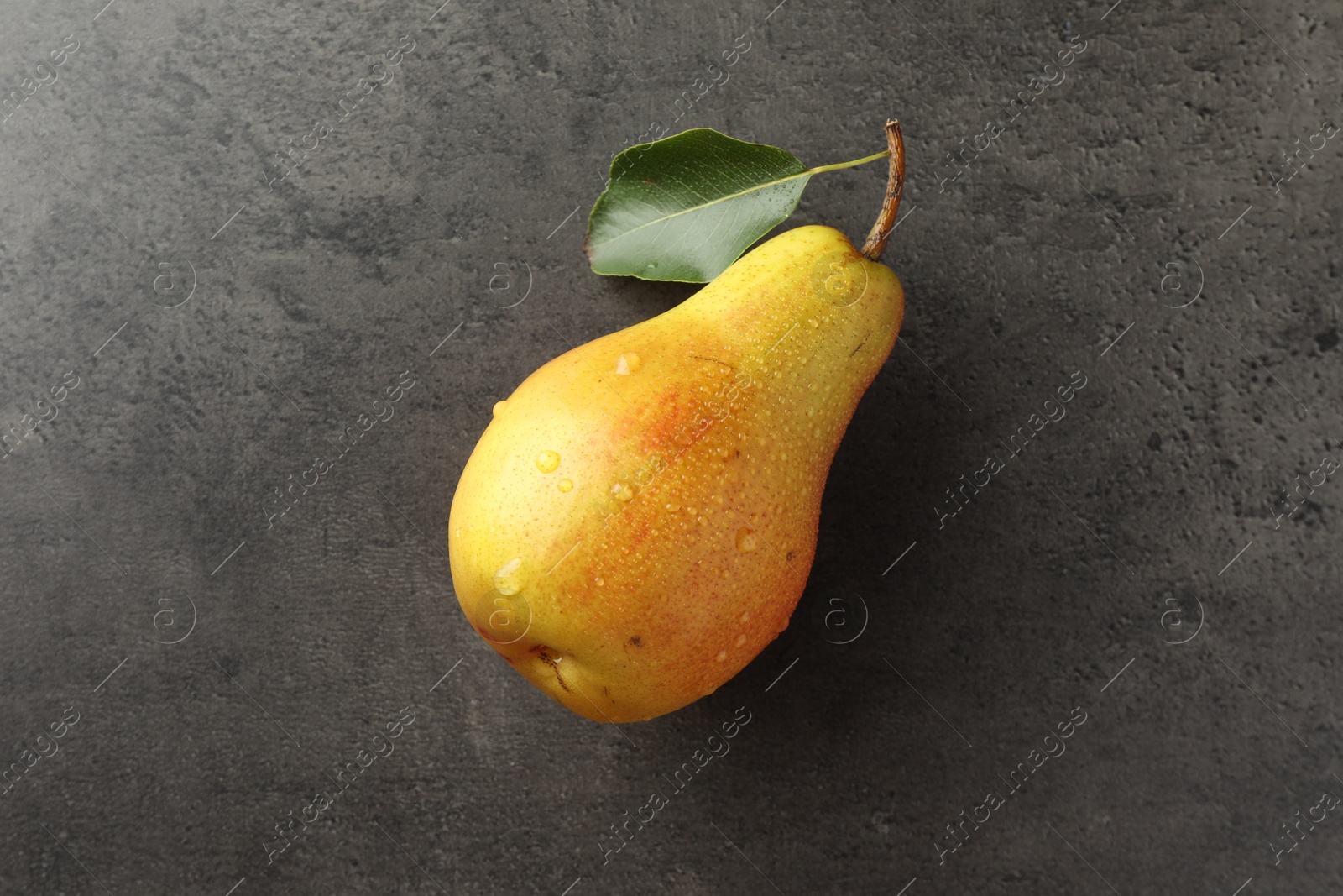 Photo of One ripe juicy pear on grey table, top view