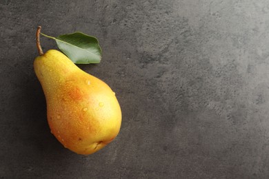 Photo of One ripe juicy pear on grey table, top view. Space for text