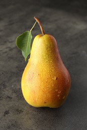 Photo of One ripe juicy pear on grey table, closeup