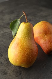 Photo of Two ripe juicy pears on grey table, closeup