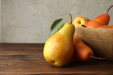 Photo of Ripe juicy pears on wooden table, closeup. Space for text