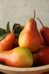 Many ripe juicy pears in bowl, closeup