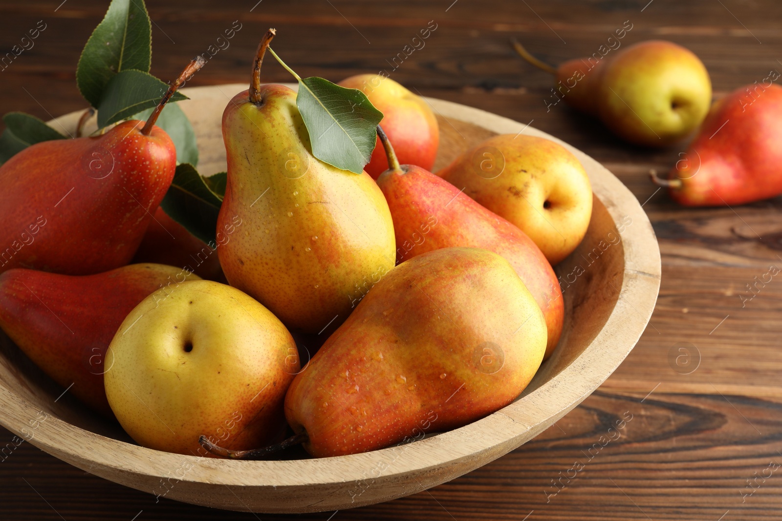 Photo of Ripe juicy pears on wooden table, closeup