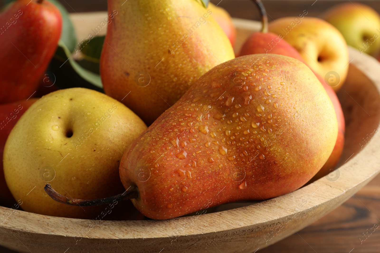 Photo of Ripe juicy pears on wooden table, closeup