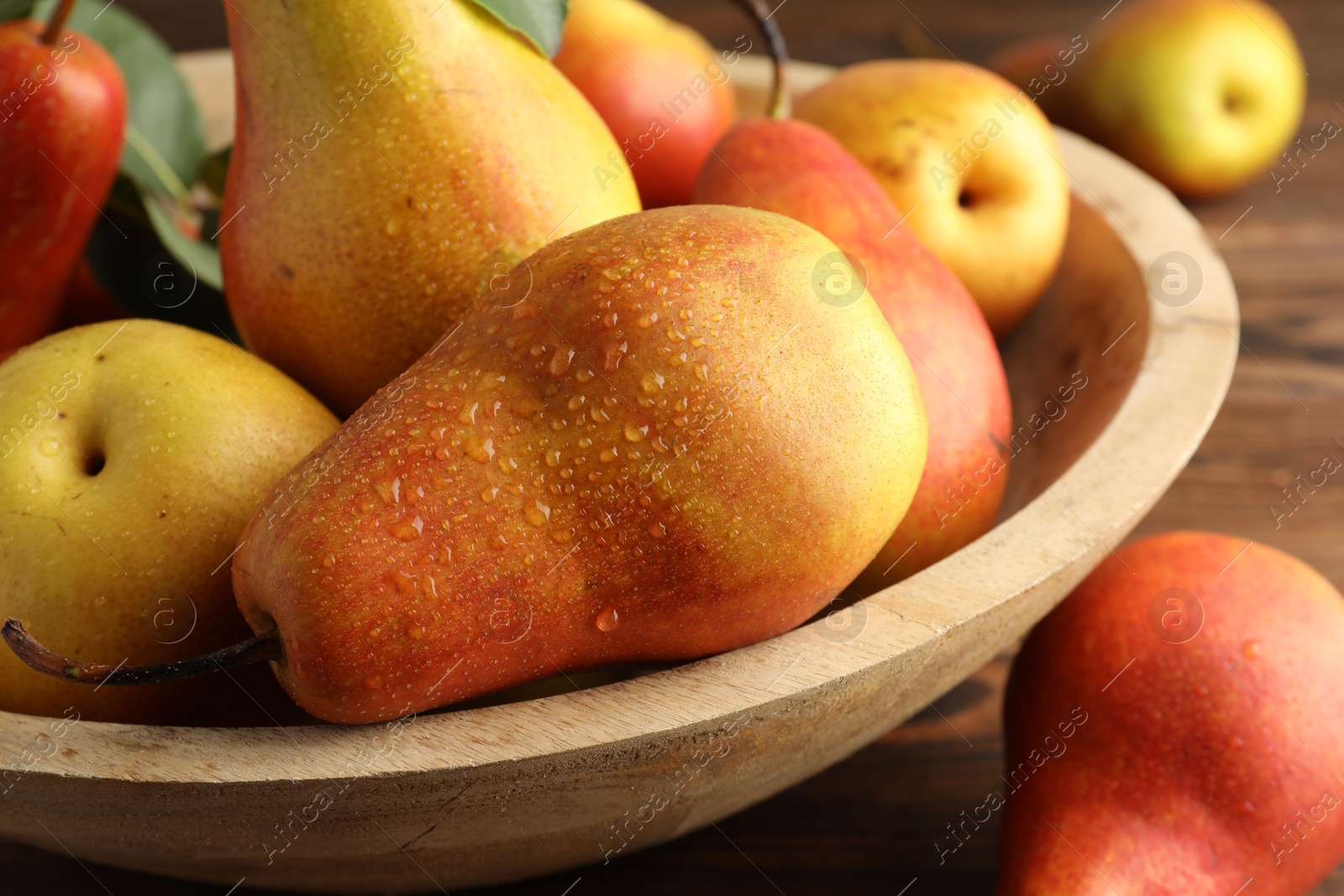 Photo of Ripe juicy pears on wooden table, closeup