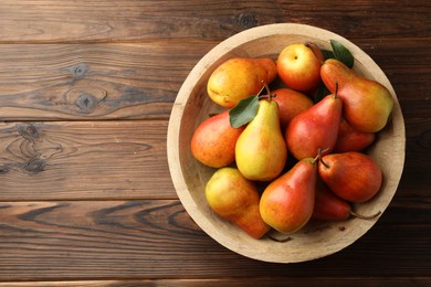 Photo of Ripe juicy pears on wooden table, top view. Space for text