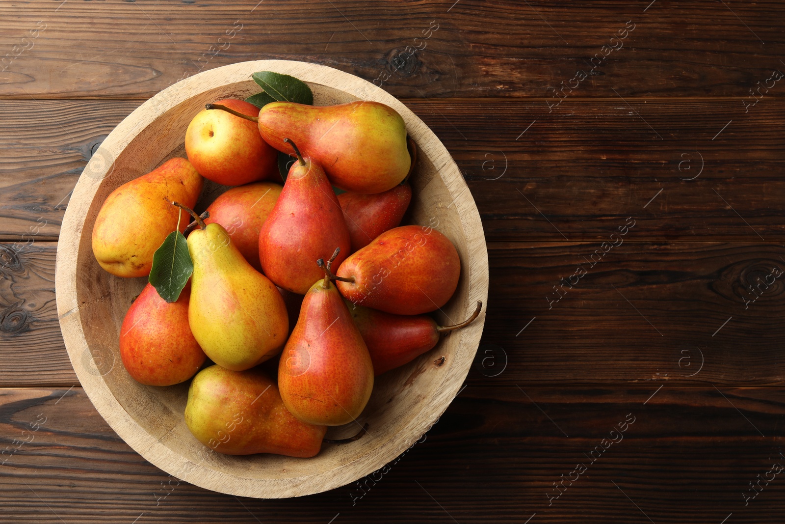 Photo of Ripe juicy pears on wooden table, top view. Space for text