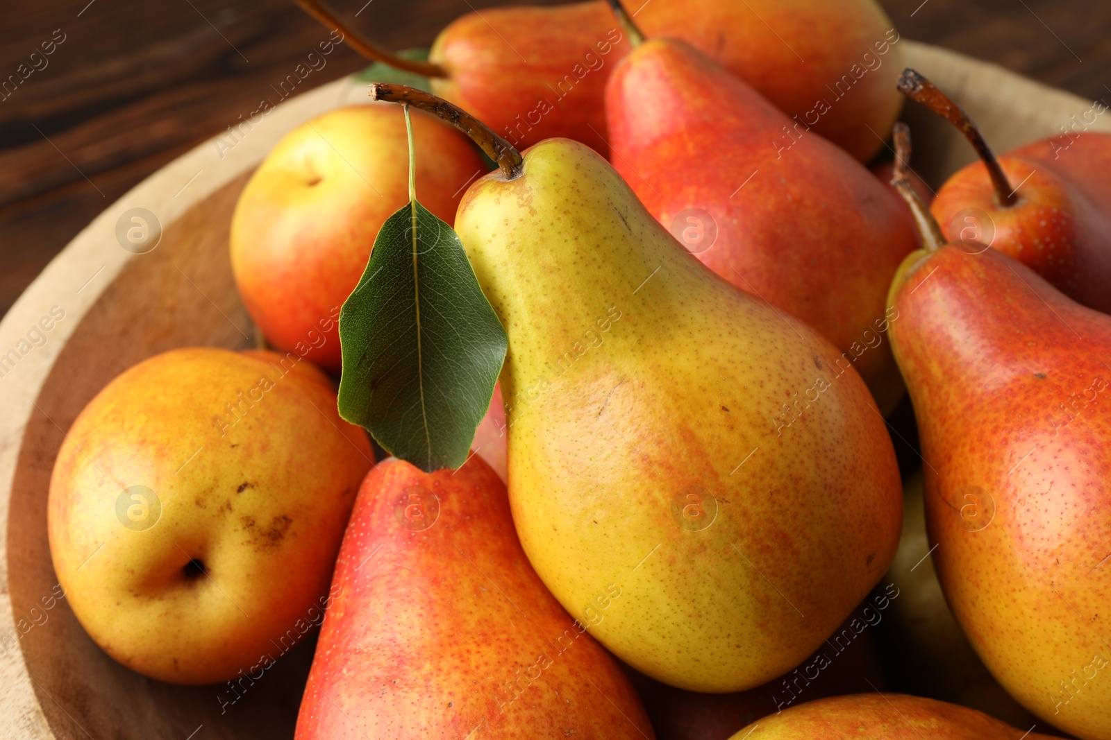 Photo of Ripe juicy pears in bowl, closeup view