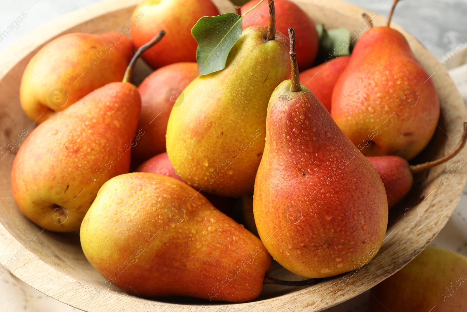 Photo of Ripe juicy pears in bowl on table, closeup