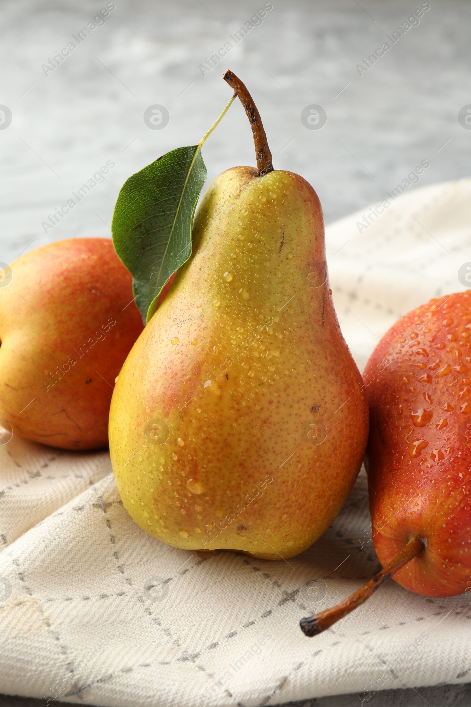 Photo of Ripe juicy pears on grey table, closeup