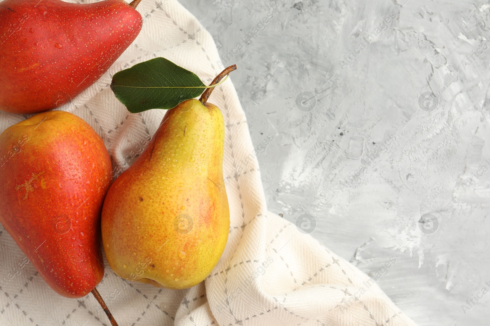 Photo of Ripe juicy pears on grey table, flat lay. Space for text