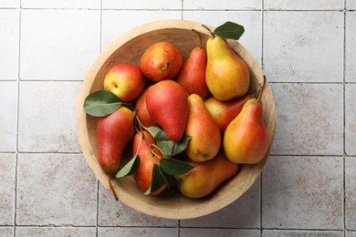 Photo of Ripe juicy pears on light tiled table, top view