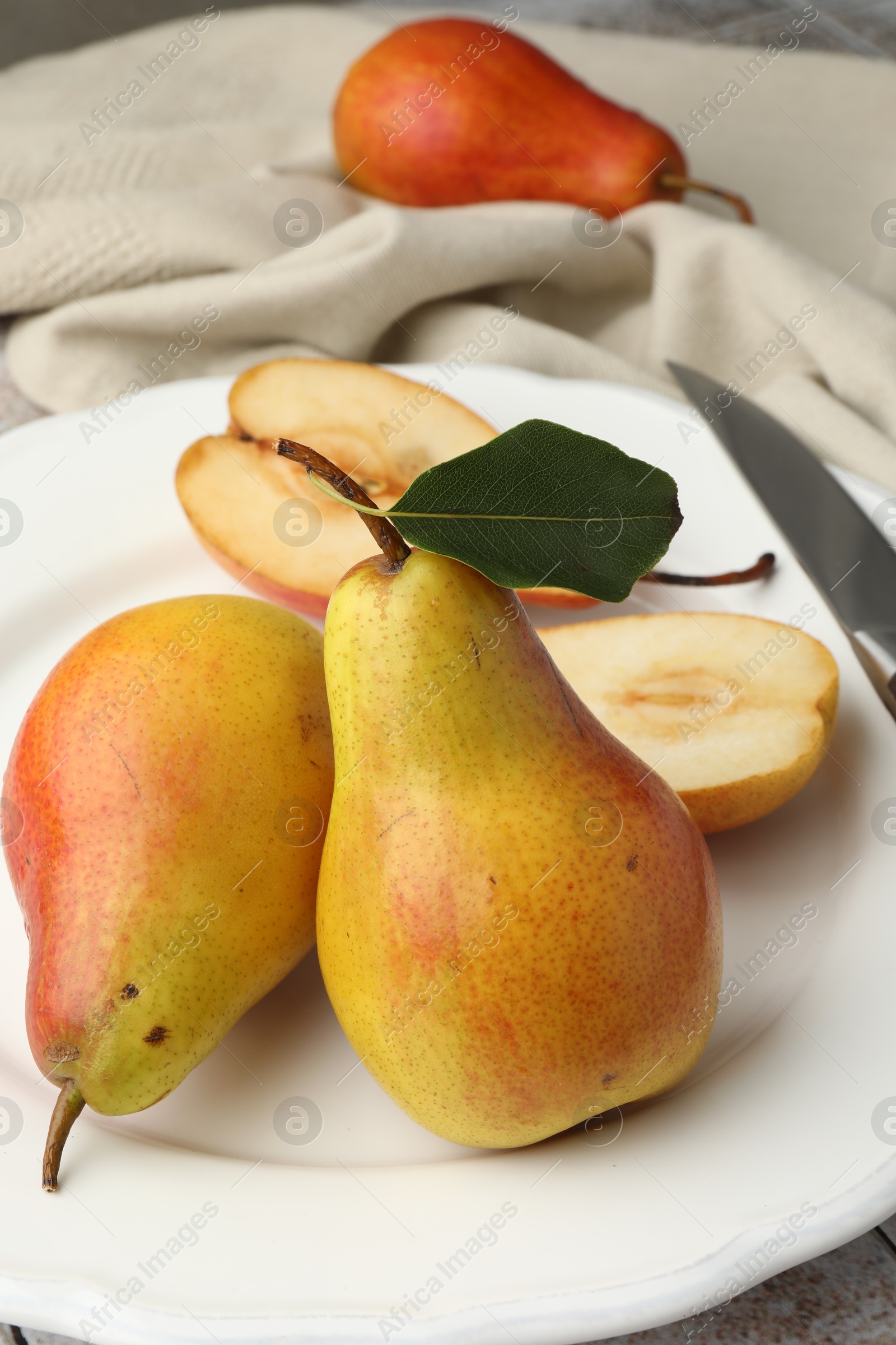 Photo of Ripe juicy pears on light tiled table, closeup