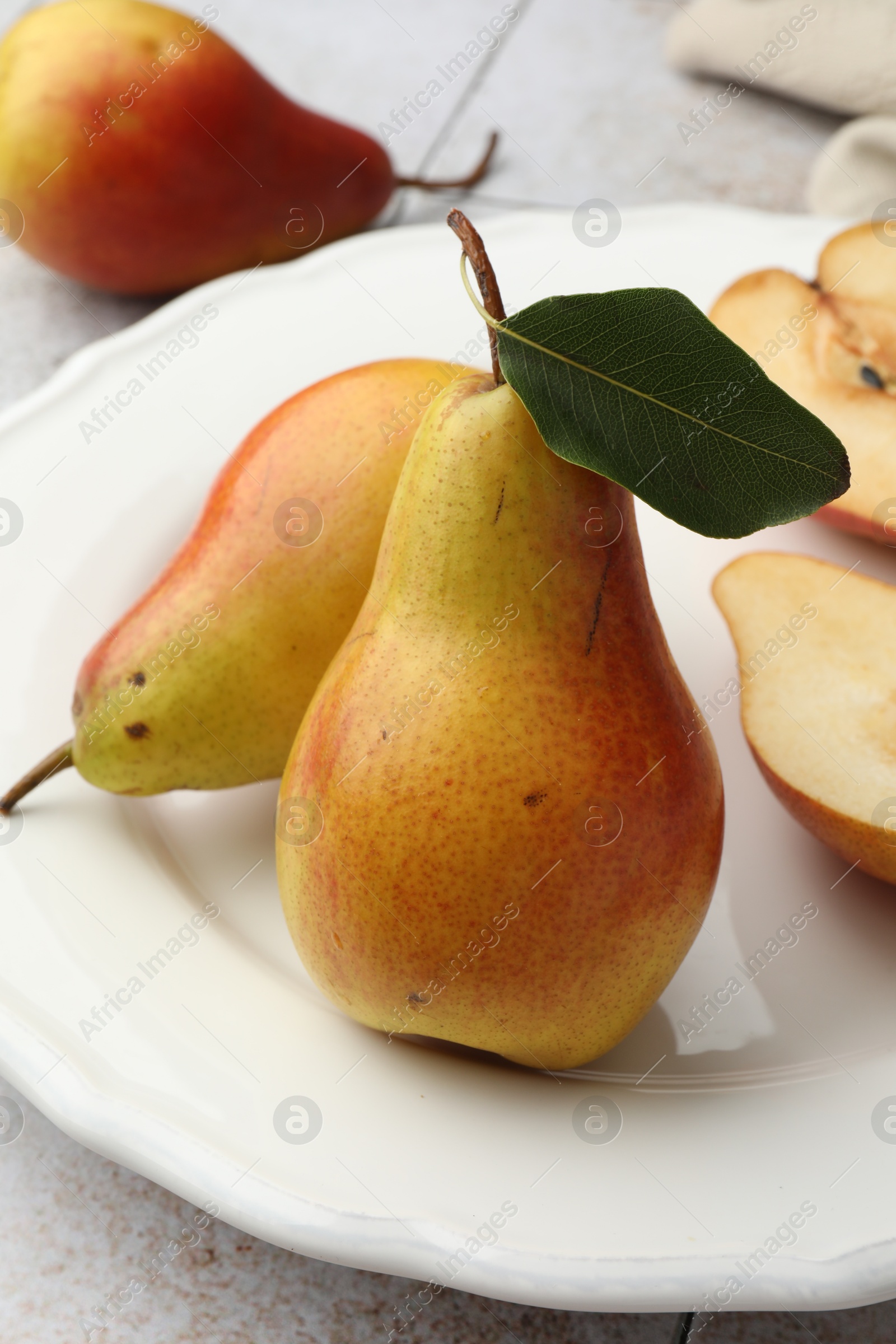 Photo of Ripe juicy pears on light tiled table, closeup