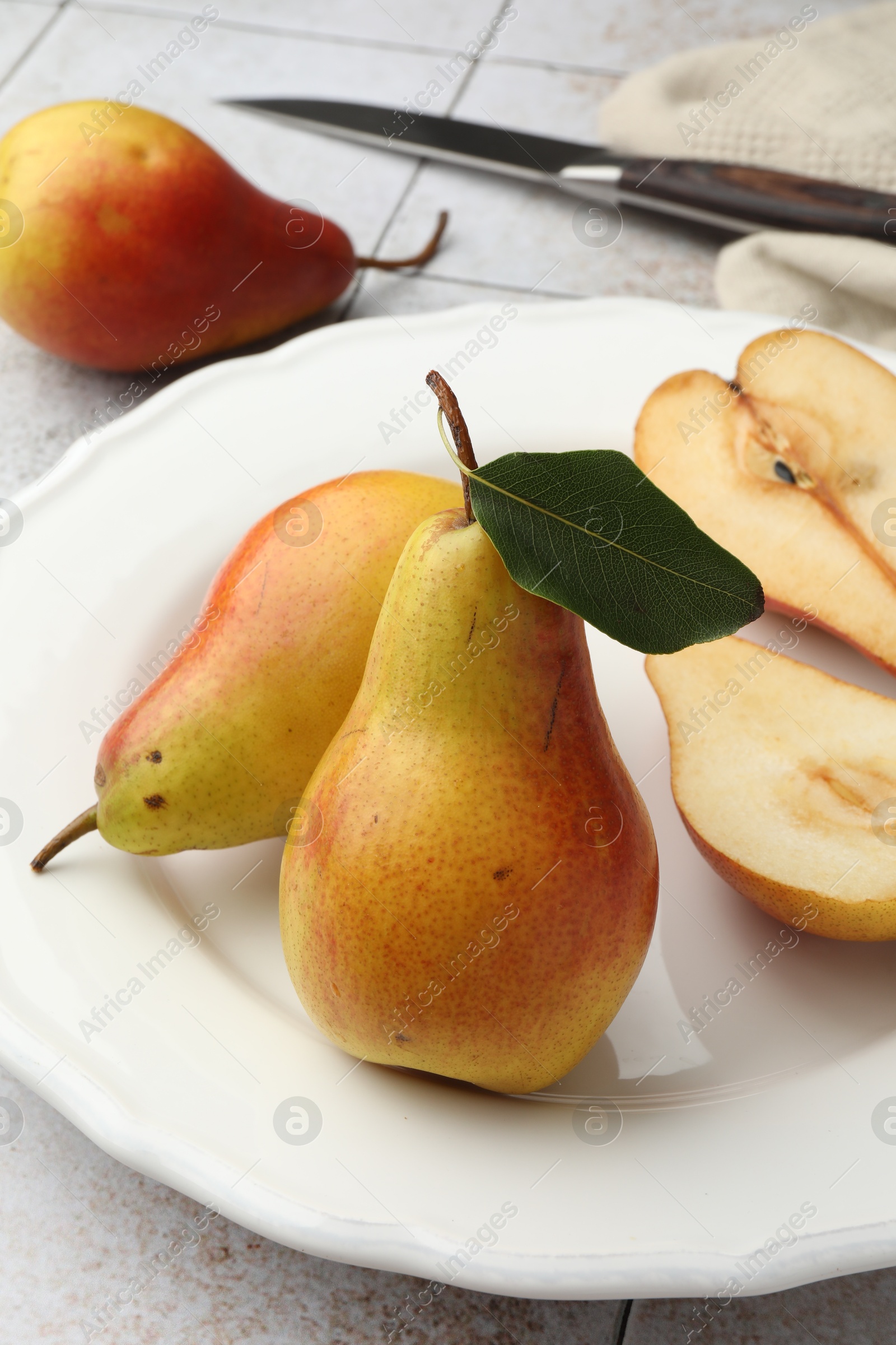 Photo of Ripe juicy pears on light tiled table, closeup