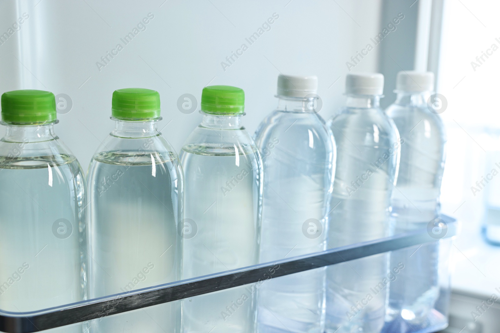 Photo of Many bottles of water in refrigerator, closeup