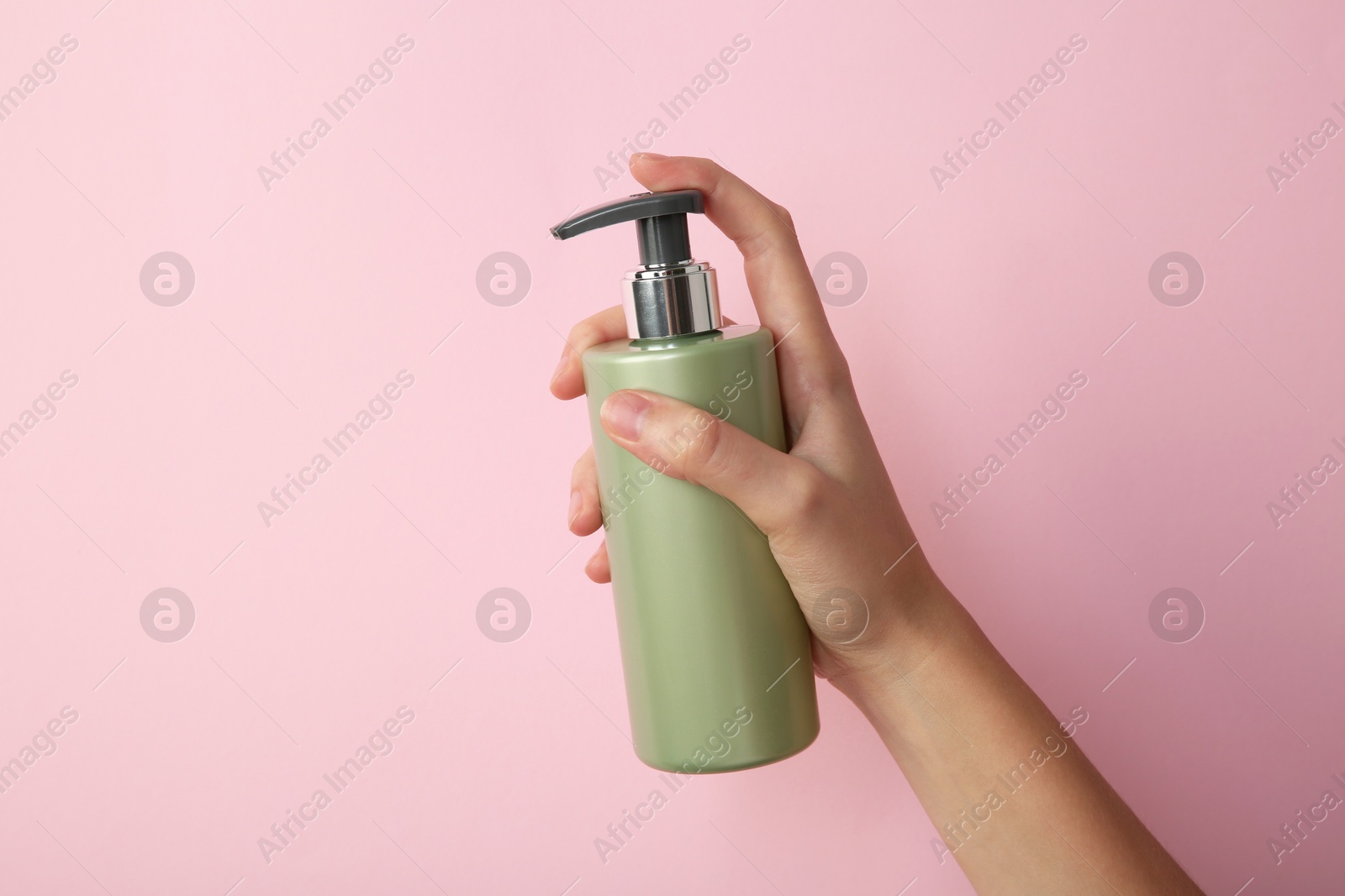 Photo of Woman with shampoo bottle on pink background, closeup