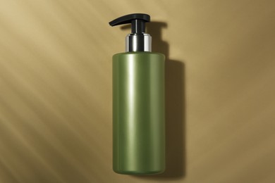 Photo of Bottle of shampoo on beige background, top view