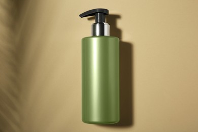 Photo of Bottle of shampoo on beige background, top view