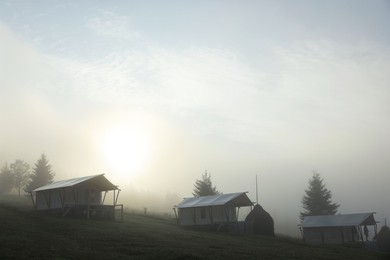 Photo of Many houses and trees covered with fog in morning