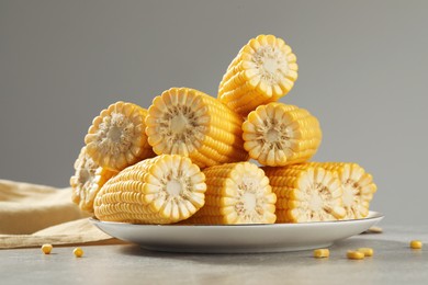 Photo of Halves of fresh ripe corncobs on grey table