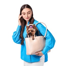 Photo of Beautiful young woman carrying cute Yorkshire Terrier dog in bag isolated on white