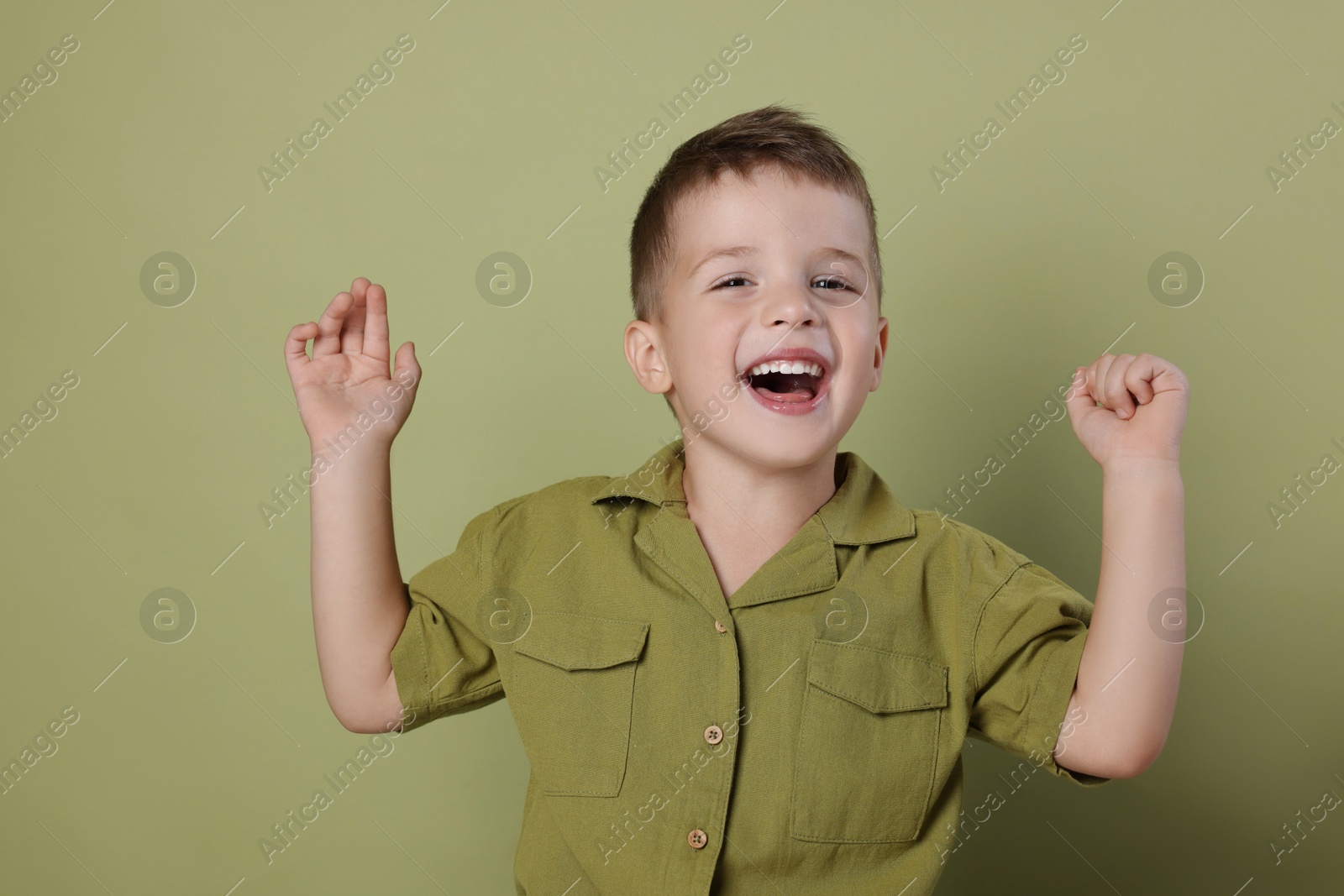 Photo of Portrait of cute little boy on green background