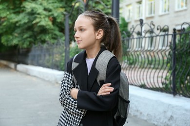 Portrait of girl with backpack on city street