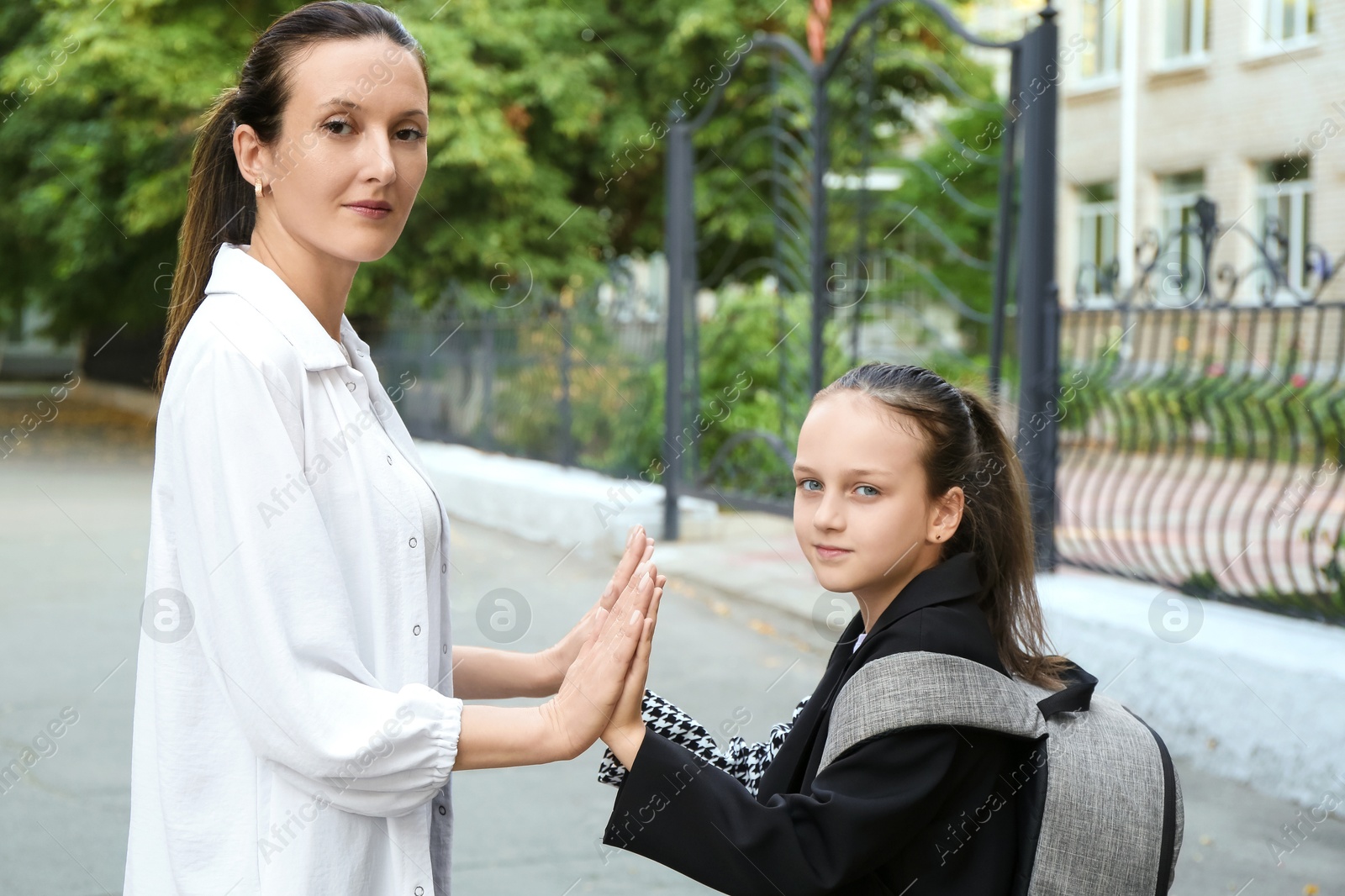 Photo of Mother and daughter holding hands on city street