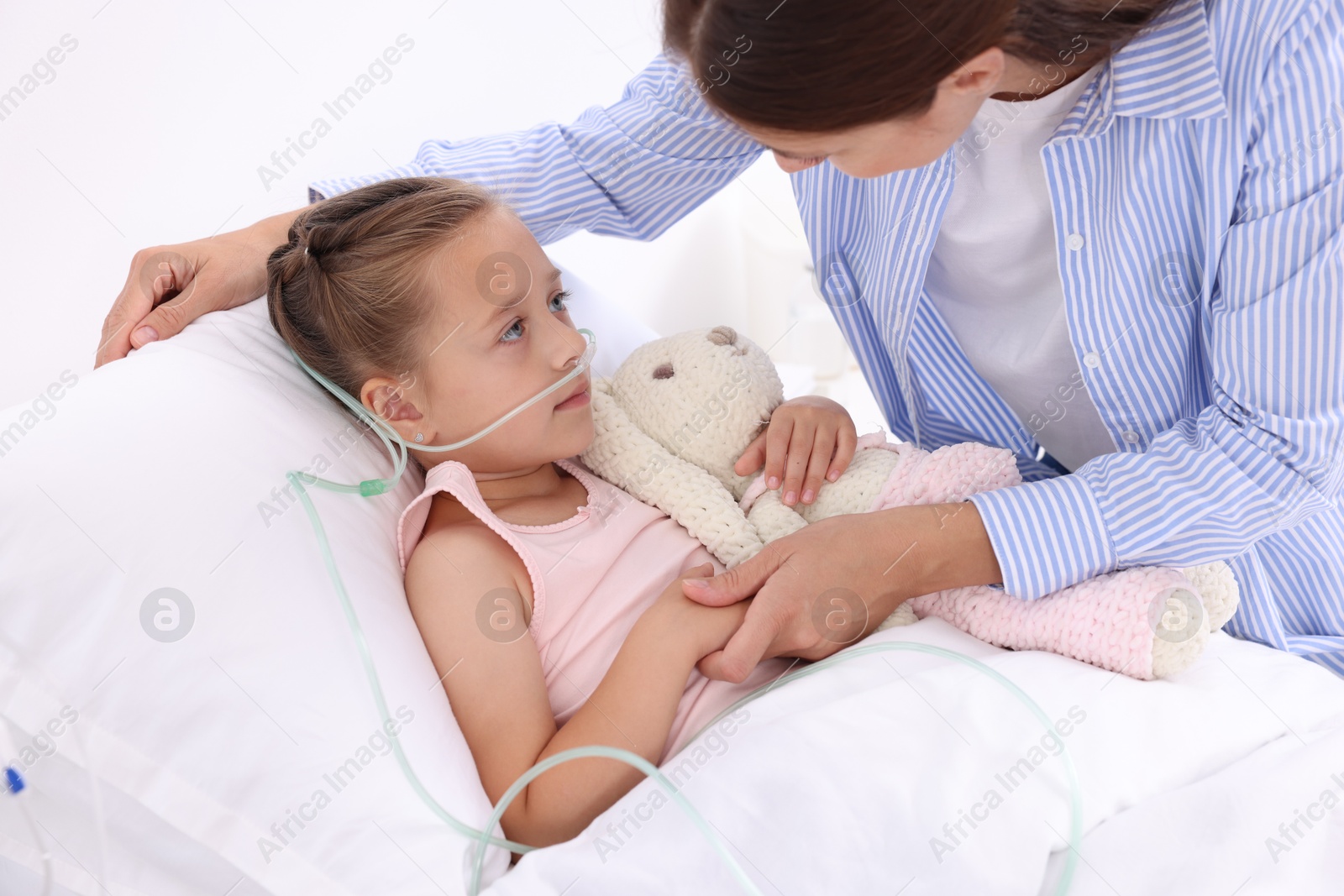 Photo of Mother and her little daughter on bed in hospital