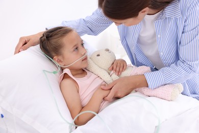 Mother and her little daughter on bed in hospital